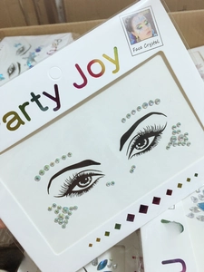 Close-up of iridescent face crystals on a white Party Joy card for festival makeup