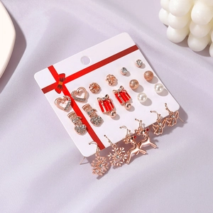 Détail de l'ensemble de boucles d'oreilles de Noël avec flocons, rennes et perles sur carte