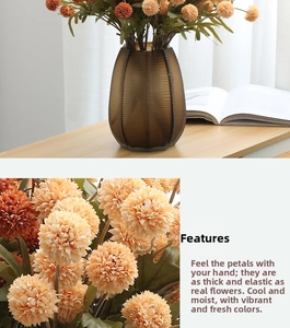 Detail of faux pompon mum with textured petals and ribbed brown vase on a desk