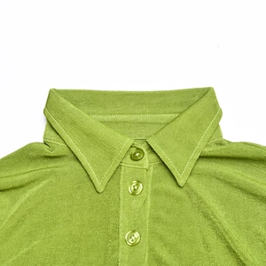 Detail view of the green knit cardigan neckline featuring three matching tone buttons