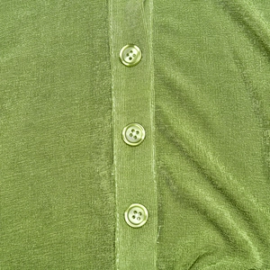 Close-up of moss green knit cardigan featuring delicate buttons and textured fabric finish