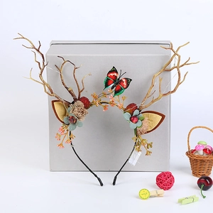 Detail of reindeer antler headband with floral berry accents and a butterfly ornament