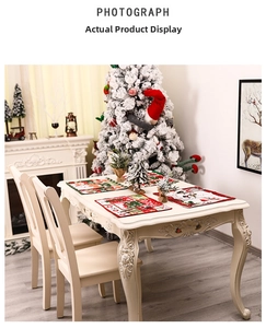Detail view of 4-pack Christmas placemats with Santa and reindeer motifs on white table
