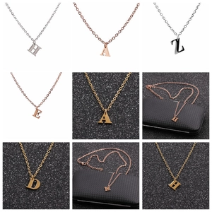 Detailed view of capital letter pendants in gold, silver, and rose gold stainless steel