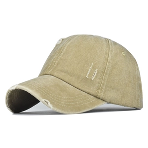 Vue détaillée d'une casquette en coton kaki délavé avec des détails de trous vintage usés
