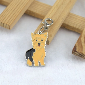 Detail view of Yorkshire Terrier enamel charm with lobster clasp on soft fur background