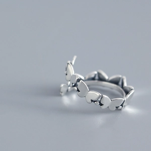 Macro shot of S925 sterling silver ring with delicate linked butterfly pattern texture