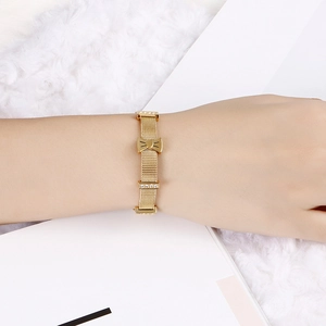 Bracelet en maille d'acier inoxydable doré avec nœud scintillant sur le poignet d'un mannequin
