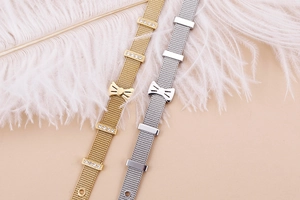 Détail de bracelets en maille avec nœud en finitions or et argent avec zircons