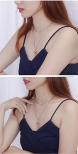 Detail view of double layer silver chain necklace with polished round ball pendant charm