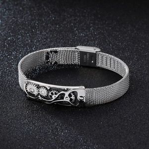 Macro view of men's stainless steel mesh bracelet with industrial gear design