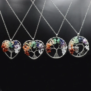 Detail of tree of life pendants in heart and round shapes with colorful natural stones