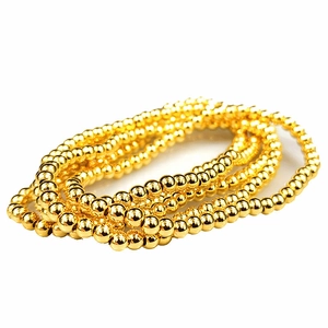 Close-up of 18K gold-plated beads showing the smooth metallic surface and reflective texture