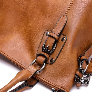Vintage brown leather shoulder bag with pebbled texture and gunmetal hardware details