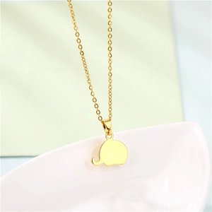 Close-up of golden elephant pendant with white shell inlay on a delicate O-chain