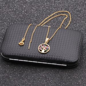 Golden Tree of Life necklace with colorful crystals on black carbon fiber jewelry box