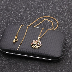 Detail view of gold Tree of Life necklace and earrings set with colorful zircon stones