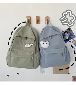 Dettaglio di zaini impermeabili casual in verde e blu con ciondoli in peluche