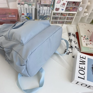 Dettaglio dello zaino in nylon azzurro impermeabile con tasche laterali a coulisse e grande capacità