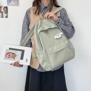 Dettaglio dello zaino in nylon impermeabile verde menta con un simpatico ciondolo a coniglio