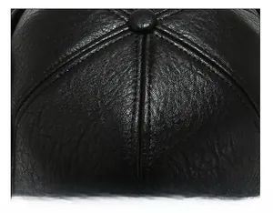 Macro shot of black leather cap top with durable stitching and round button detail