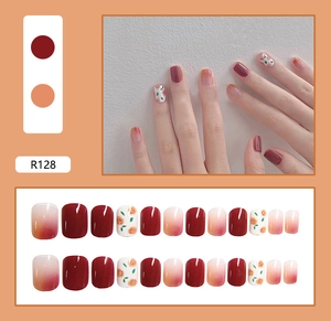 Detail view of R128 press-on nails featuring wine red, peach gradient and floral patterns