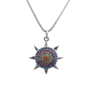 Close-up of silver box chain necklace with multi-colored cubic zirconia sunburst pendant