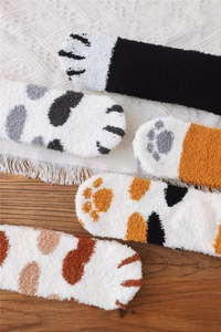 Close-up of soft coral fleece cat paw socks with fluffy textures and cute animal patterns