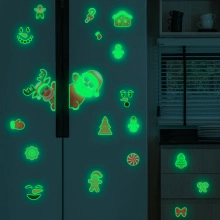 Glow-in-the-dark Christmas magnets showing Santa and reindeer on a dark fridge surface