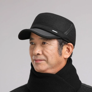 Close-up of black winter flat cap with SPORT metal side emblem and thick fabric detail