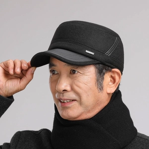 Detail of men's winter flat cap with ear protection and metal sport logo decoration