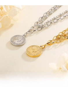 Close-up of gold and silver coin necklaces with queen portrait engraving and mixed chain links