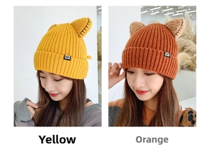 Close-up of thick ribbed knit texture on cat ear winter hats in yellow and orange