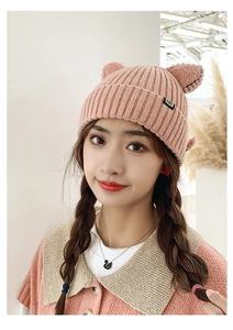 Close-up of pink knit beanie featuring cute cat ears and a black CAT label detail