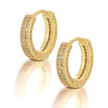 Détail de boucles d'oreilles hip hop dorées avec sertissage pavé de zircones blanches en rangs