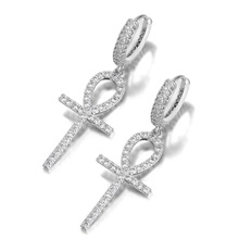 Vue macro de boucles d'oreilles croix d'Ankh en argent serties de zircons cubiques