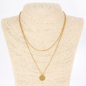 Double-layered gold chain necklace featuring a minimalist round pendant on a bust