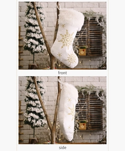 Detail of plush white Christmas stocking with gold snowflake embroidery and faux fur trim