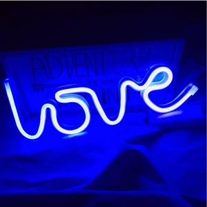 Macro detail of blue neon LED sign forming the word love for romantic party decoration