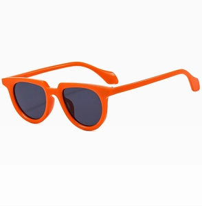Detail view of bright orange small frame sunglasses with dark grey UV protective lenses