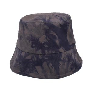 Gros plan détaillé du motif tie-dye gris et bleu marine sur un chapeau bob en coton