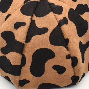 Detailed macro view of the leopard print wool felt fabric and fine stitching on the beret