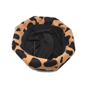 Detailed top view showing the cow print pattern and black inner lining of this wool beret