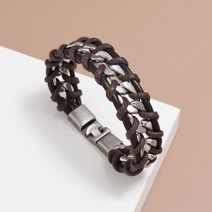 Detail of men's braided brown leather bracelet with silver metal chain on white cube pedestal