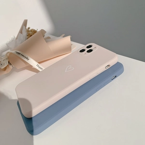 Detailed view of matte iPhone cases in soft pink and blue with a minimalist white heart