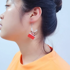 Christmas reindeer gift box drop earrings worn by a model against a white background