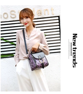 Detail of purple leopard print and crocodile texture women bag with gold metal buckle