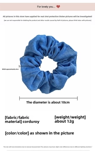 Blue corduroy scrunchie showing ribbed texture and soft fabric detail on white background