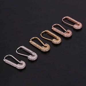 Dettaglio di orecchini a forma di spilla con zirconi in oro, argento e oro rosa lucido