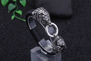 Nahaufnahme der doppelten Löwenkopf-Schnitzereien mit Mittelring am schwarzen Lederarmband